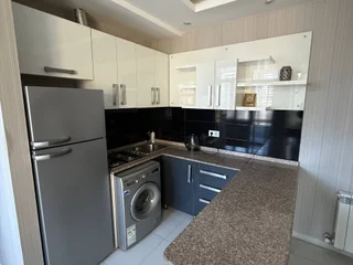 Кухня с газовой плитой, барной стойкой и посудой
